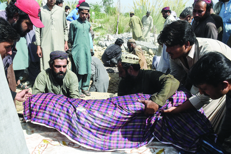 HARNAI, Pakistan: Residents bury the body of a victim following an earthquake in the remote mountainous district of Harnai yesterday.-AFPn
