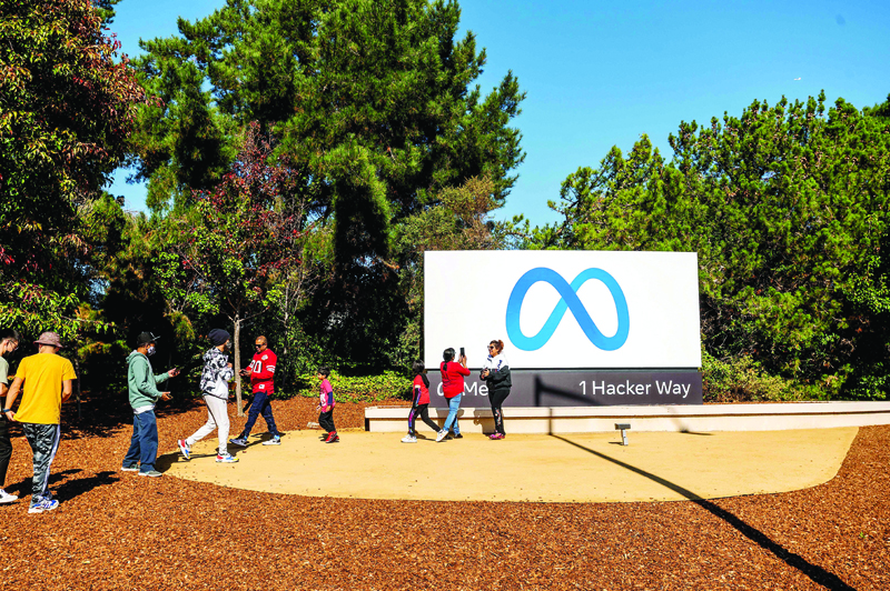 MENLO PARK: People visit a newly unveiled logo for 'Meta' - the new name for Facebook's parent company, outside Facebook headquarters in Menlo Park. - AFP n