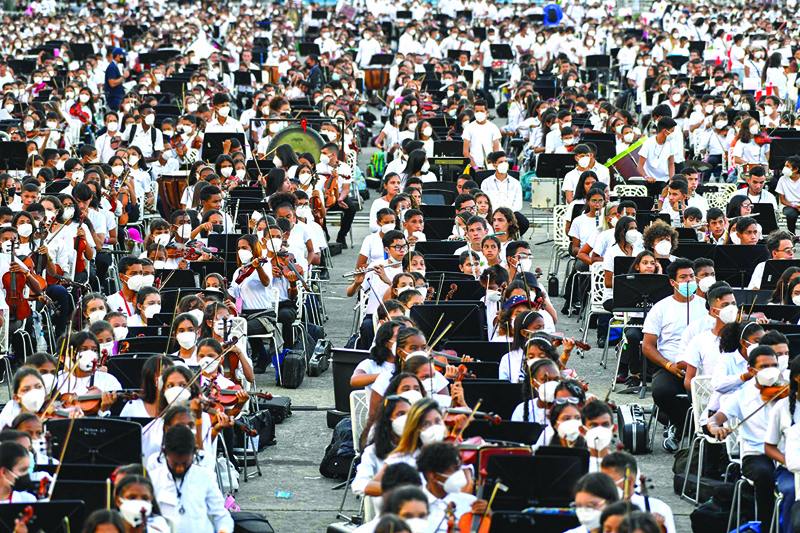 Members of the National System of Orchestras of Venezuela play during an attempt to enter the Guinness Book of Records for the largest orchestra in the world, with more than 12,000 musicians, at the Military Academy of the Bolivarian Army in Fuerte Tiuna Military Complex, in Caracas.-AFP photosn