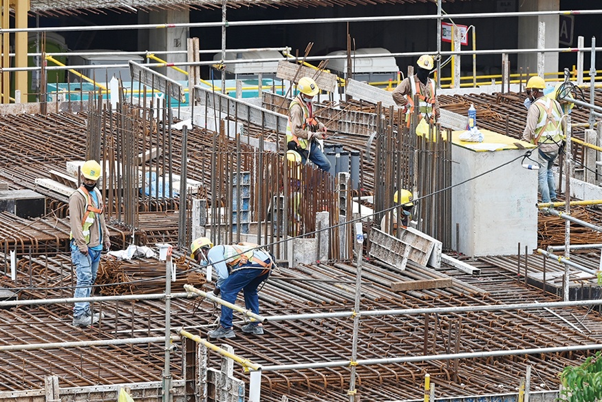 SINGAPORE: In this photograph taken yesterday migrant workers are pictured working at a construction site in Singapore. —AFP