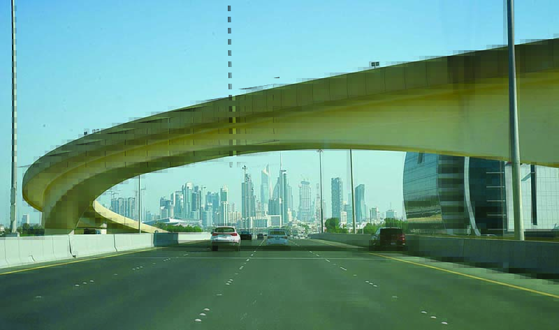 KUWAIT: Vehicles drive along a highway as Kuwait City's skyline is seen. - Photo by Fouad Al-Shaikh