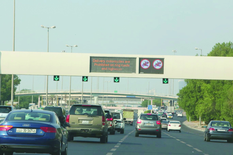 KUWAIT: Vehicles drive on a highway in Kuwait as a signboard shows a notice warning delivery motorbikes from using highways, after the ban went into effect yesterday. - Photo by Yasser Al-Zayyatn