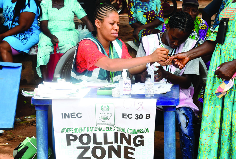 ISUOFIA, Nigeria: An electoral official accredits a woman to vote at a polling station during the Anambra State governorship election at Uga, Aguata district in southeast Nigeria. - AFP n