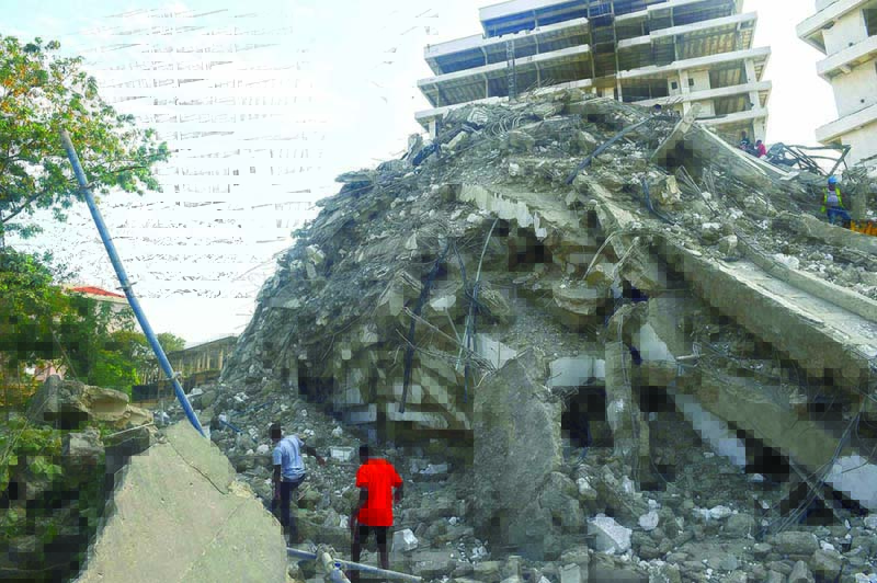 LAGOS: People walk to rescue workers from the rubble of a 21-storey building under construction that collapsed at Ikoyi district of Lagos. - AFP n
