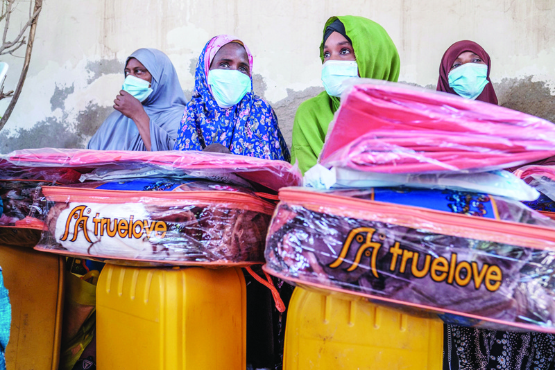 HARGEISA, Somalia: Ethiopian migrants sit behind several items during an assistance packages distribution for migrants at an International Organization for Migration (IOM) center in the city of Hargeisa, Somaliland. - AFPnn