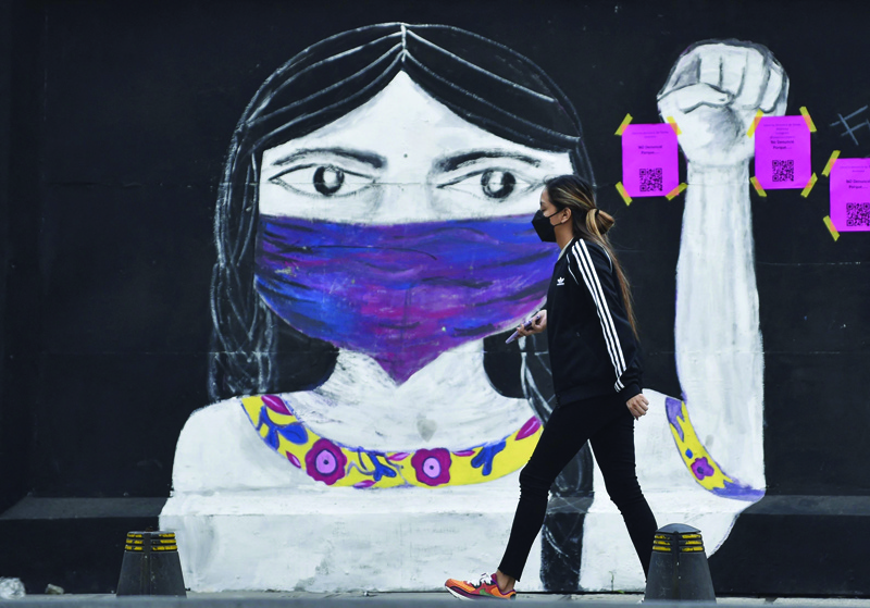 MEXICO CITY: A woman walks in front of a graffiti before a demonstration on the International Day for the Elimination of Violence against Women in Mexico City. - AFPn