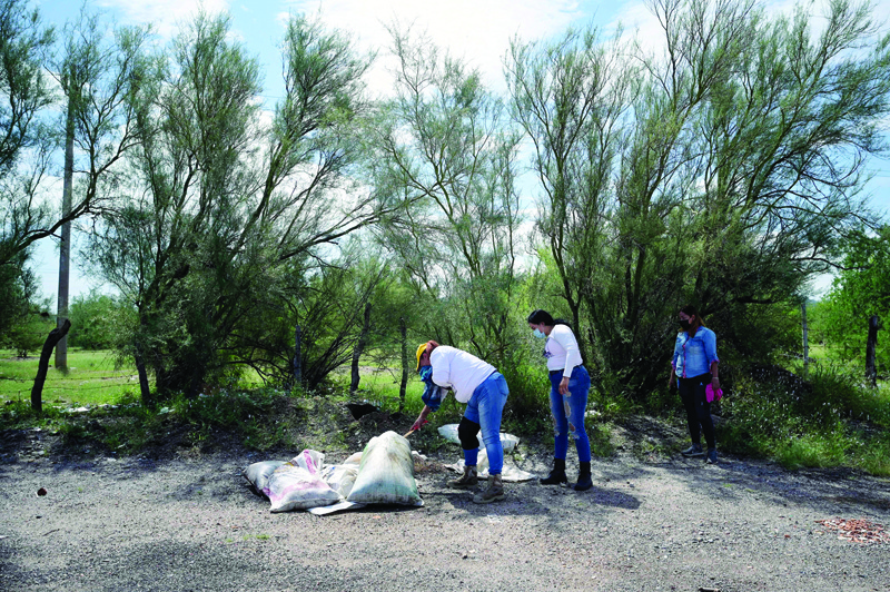 HERMOSILLO: Members of the Madres Buscadoras de Sonora (Seeker Mothers of Sonora) civil organization review sacks with possible human remains inside, on the side of the road, in the outskirts of Hermosillo. - AFPnn