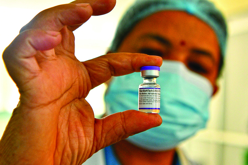 KATHMANDU: A health worker shows a vial of the Pfizer-BioNTech vaccine against the COVID-19 coronavirus in Kathmandu after the government began a drive to vaccinate people above the age of 12 years and those with chronic health diseases. - AFP n