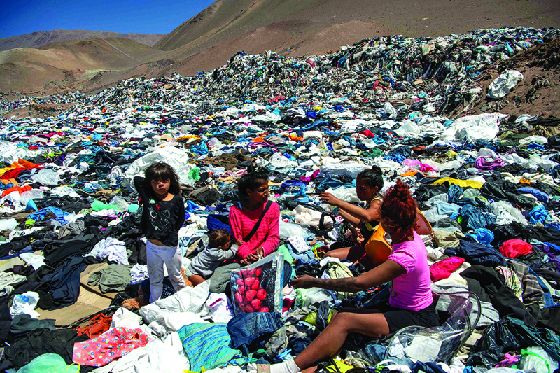Women search for used clothes amid tons discarded in the Atacama desert, in Alto Hospicio, Iquique, Chile.—AFP photosn