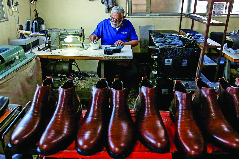 Craftsman Youssef Abu Sariya, who works for shoemaker Zuhair Shiha at the Marina workshop, assembles a shoe at the shop in Jordan's capital Amman.—AFP photosn