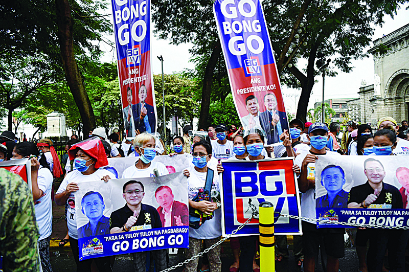 MANILA: File photo shows supporters of Philippine senator and presidential candidate Bong Go (pictured on placards) hold a rally in front of the commission on elections office in Manila, on the final day for candidates to file for the presidential and vice presidential races in 2022. - AFPnn