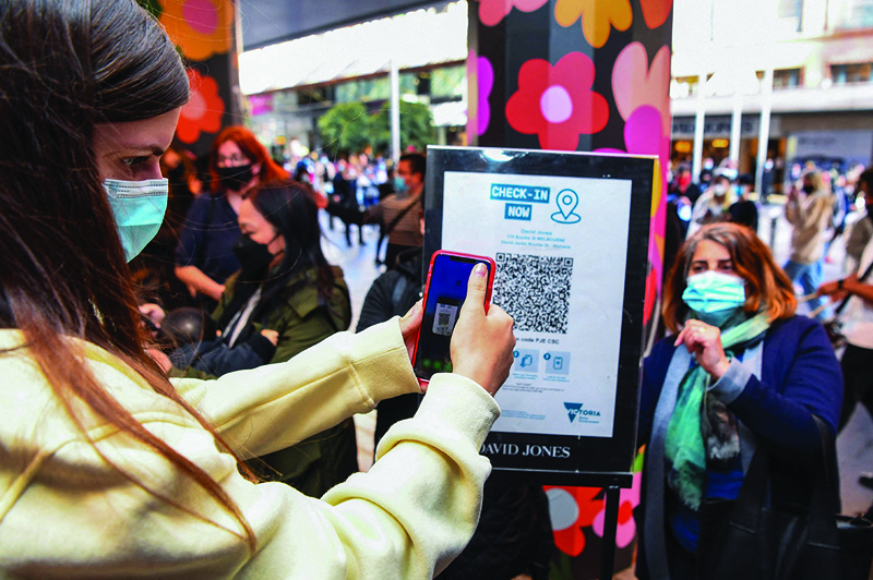 MELBOURNE: A customer scanning a QR code to enter a department store in Melbourne as the city further lifts COVID restrictions allowing non-essential retail shops to open and travel to the regions of Victoria after the city's sixth lockdown. - AFP n
