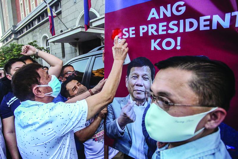 MANILA: Philippine President Rodrigo Duterte (left) sprays paint over the word 'vice' as senator Christopher 'Bong' Go amended his candidacy to run for president in the 2022 elections before the November 15 deadline at the Commission on Election in Manila.- AFP n