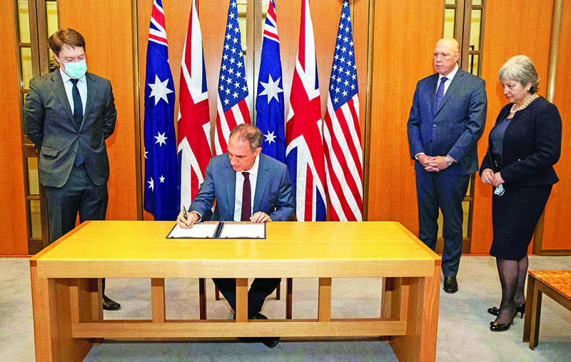 CANBERRA: Handout photo taken and released on November 22, 2021 by the Australian Defence Force shows US Charge d’Affaires Michael Goldman (2nd L) signing the Exchange of Naval Nuclear Propulsion Information Agreement as Australia's Minister for Defence Peter Dutton (2nd R) and British High Commissioner Victoria Treadell (R) look on during a ceremony at Parliament House in Canberra. – AFPn
