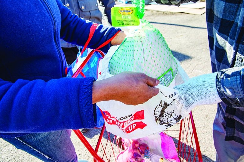 CHELSEA, US: A whole turkey is placed into a shopping bag before being placed into a cart at the La Colaborativa Food Pantry in Chelsea, Massachusetts on Wednesday.-AFPn nn