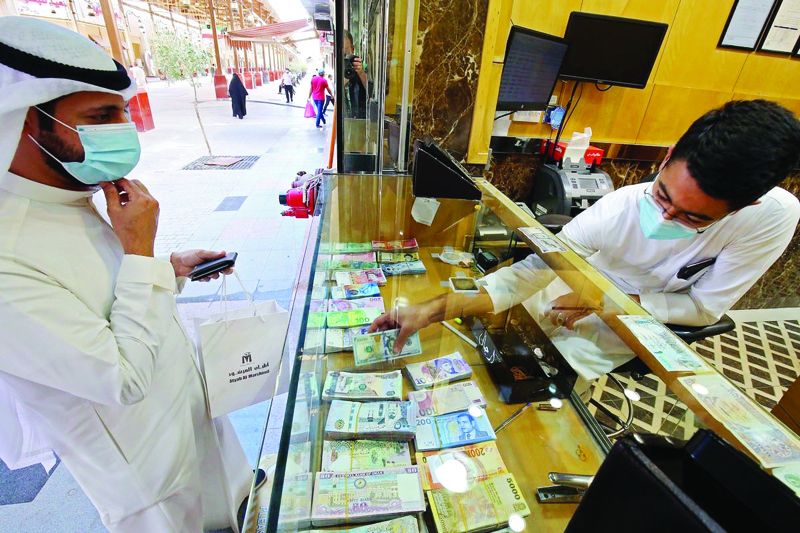 KUWAIT: A citizen checks the forex rates at a currency exchange shop in Kuwait City in this file photo. - Photo by Yasser Al-Zayyatn