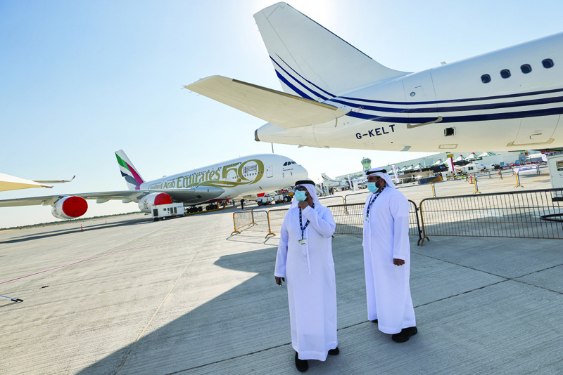 DUBAI: Two men stand next to an Acropolis Aviation Airbus A320-251N aircraft while in the background is seen another Emirates Airbus A380 aircraft on the tarmac at the 2021 Dubai Airshow in the Gulf emirate yesterday. nn