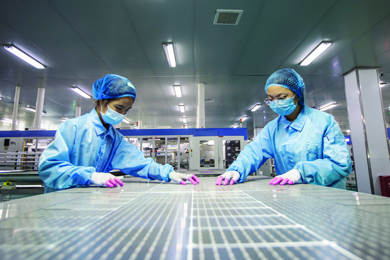 HAIAN, China: Employees work on solar photovoltaic modules at a factory in Haian in China's eastern Jiangsu province yesterday.-AFPn