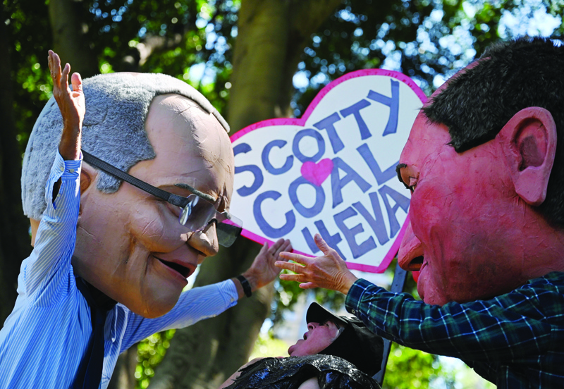 SYDNEY: People wear caricatures of Australian Prime Minister Scott Morrison (left) and Deputy Prime Minister Barnaby Joyce (right) during a rally as part of a global day of action on climate change in Sydney as world leaders attend the COP26 UN Climate Change Conference in Glasgow. - AFPnn