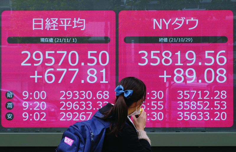 TOKYO: A pedestrian walks past an electronic quotation board displaying share prices of the Tokyo Stock Exchange in Tokyo yesterday.-AFPnn