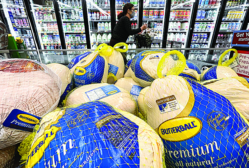 WASHINGTON: In this file photo taken on November 11, 2021 a shopper walks past turkeys displayed for sale in a grocery store ahead of the Thanksgiving holiday in Los Angeles, California. --AFPnn