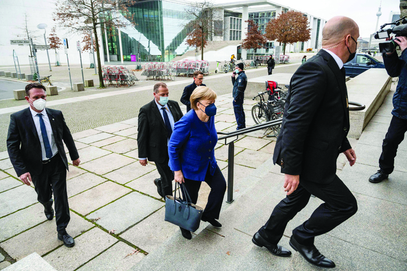 BERLIN: German Chancellor Angela Merkel walks into the Reichstag building to attend a session at the Bundestag, the lower house of parliament, yesterday in Berlin, where the parliament is to examine proposed new COVID-related restrictions. - AFPnn