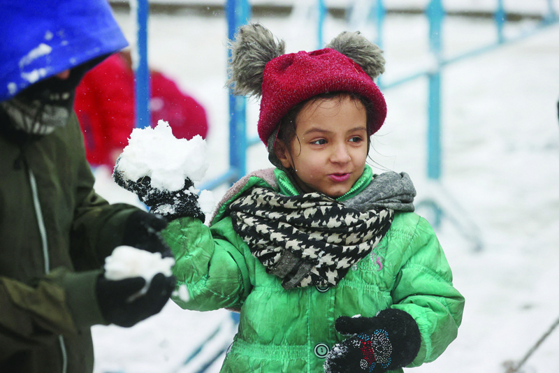 GRODNO, Belarus: Migrant children play with snow outside the transport and logistics centre near the Bruzgi border point on the Belarusian-Polish border in the Grodno region yesterday. - AFPnn