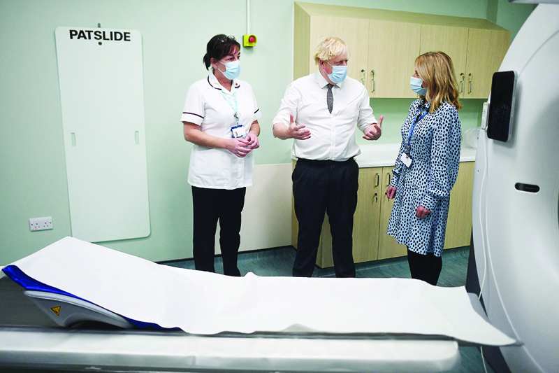 NORTHUMBERLAND: Britain's Prime Minister Boris Johnson (center) is shown around a CT scan room during a visit to Hexham General Hospital yesterday in Hexham in northern England. - AFP n