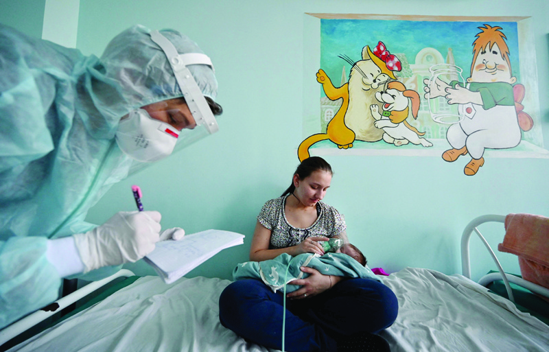 KIEV: A woman holds an oxygen mask over the face of her baby suffering from the coronavirus disease (COVID-19) in a ward of a children's hospital in Kiev. - AFPnnn