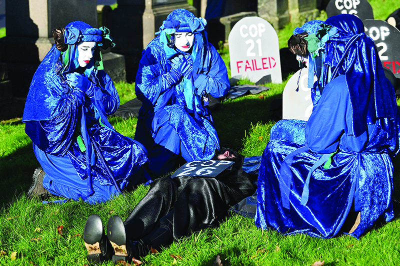 GLASGOW: Performers from the Blue Rebels conduct a funeral ceremony at Glasgow Necropolis to symbolize the failure of the COP26 process at Glasgow Cathedral yesterday during the COP26 UN Climate Change Conference. — AFP