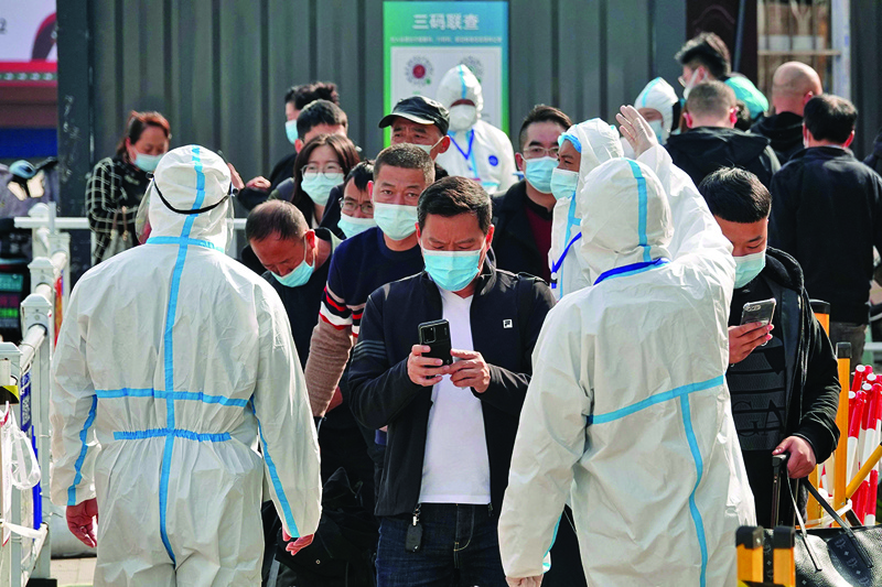 YANTAI, China: Health workers guide travelers to a COVID-19 inspection station at Yantai railway station in Shandong province yesterday. – AFP n