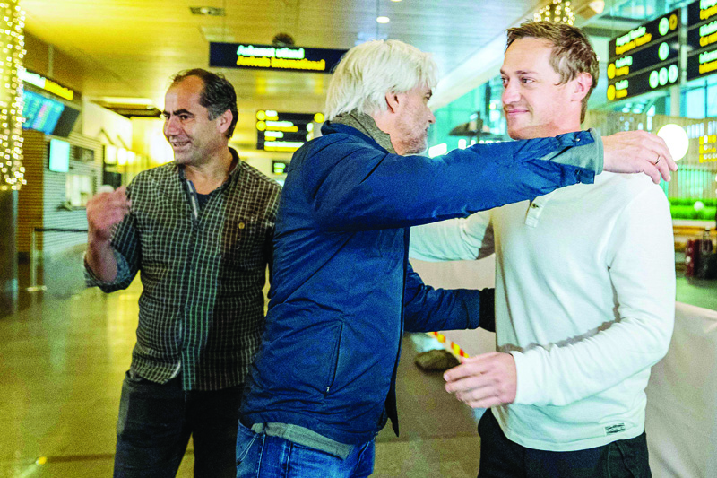 GARDERMOEN: NRK journalists Halvor Ekeland (right) and Lokman Ghorbani (left) are welcomed by head of NRK sports Egil Sundvor in Gardermoen yesterday, after returning from Qatar where they were arrested in connection with a reportage trip. - AFP n