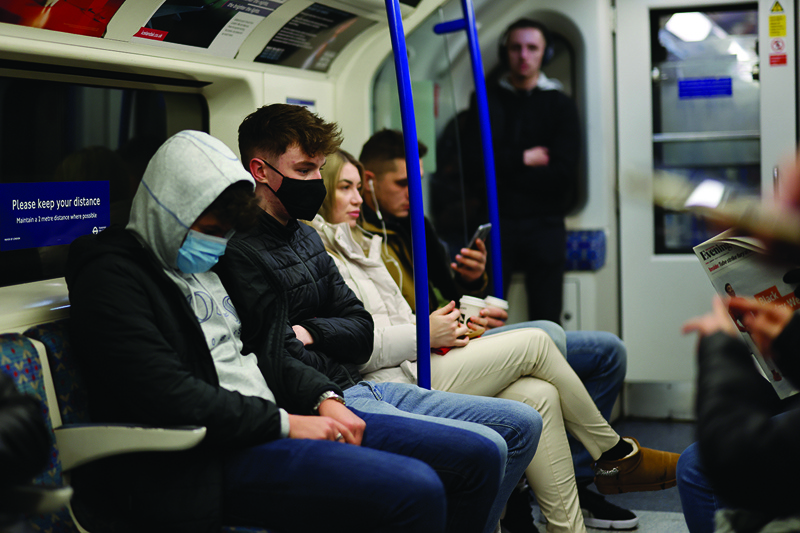 LONDON: Passengers, some wearing face coverings to combat the spread of COVID-19, travel on the London underground in central London yesterday.-AFPnn