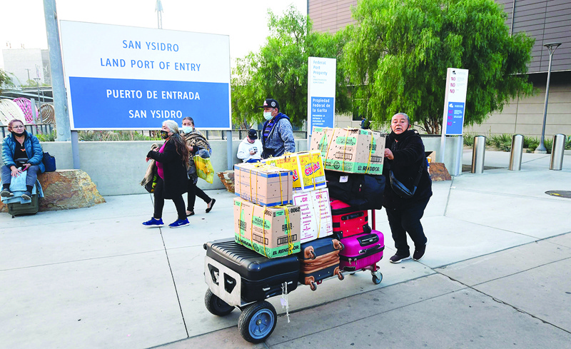 SAN YSIDRO, California: A woman pushes a cart with luggage and boxes upon entry from Mexico into the United States at the San Ysidro Land Port Entry yesterday. - AFP nn