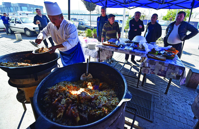 Chef Abdurahim Mirzayev, 59, cooks plov - a dish known around the world as pilaf, in a small cafe in Tashkent.—AFP photosn