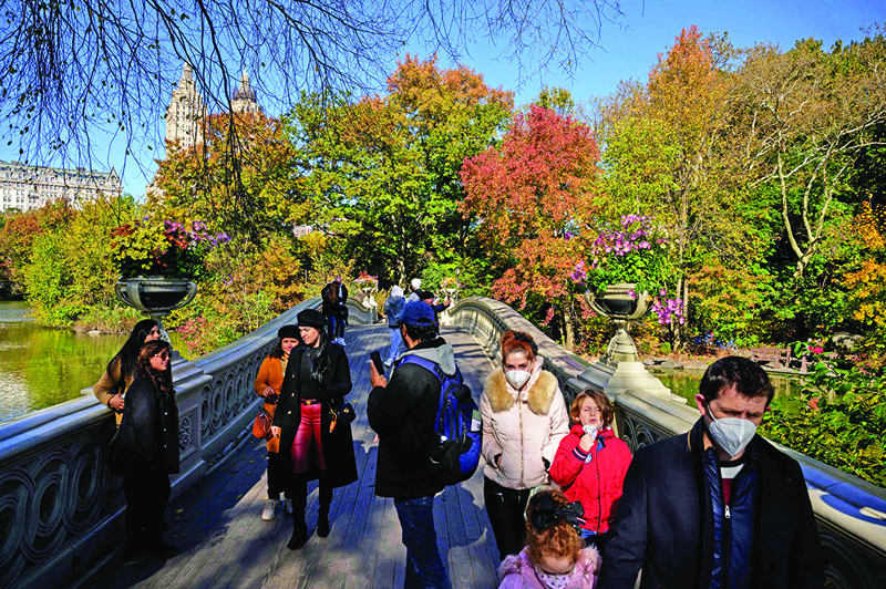 People walk over the Bow Bridge before fall foliage in Central Park in New York.—AFP photosn
