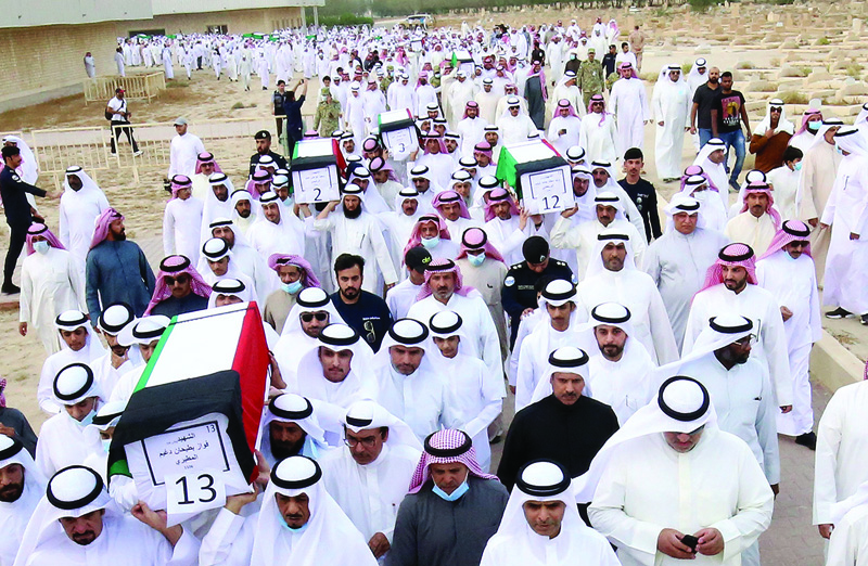 KUWAIT: Mourners carry the coffins of 19 Kuwaiti prisoners of war (POWs) whose remains were recently found in a mass grave in Iraq. - Photo by Yasser Al-Zayyatn