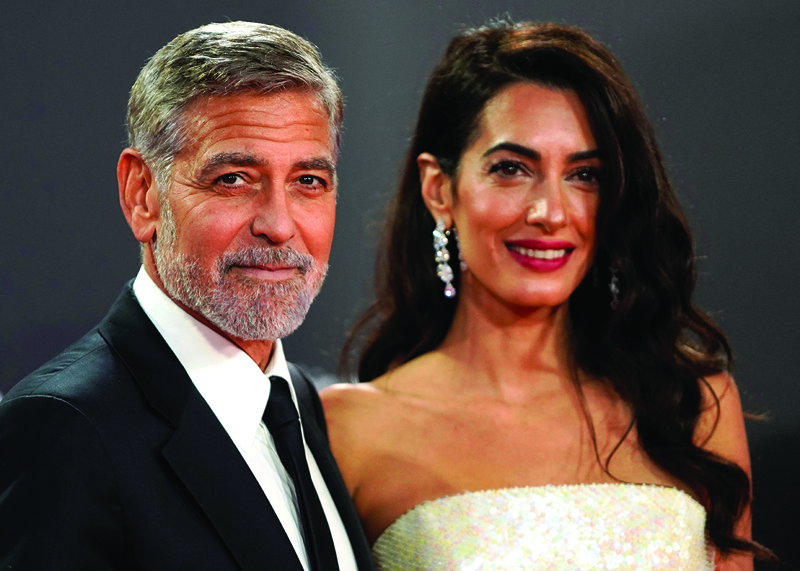 In this file photo US actor George Clooney and his wife Lebanese-British barrister Amal Clooney pose on the red carpet on arrival to attend the UK premiere of the film 'The Temple Bar'.—AFP n