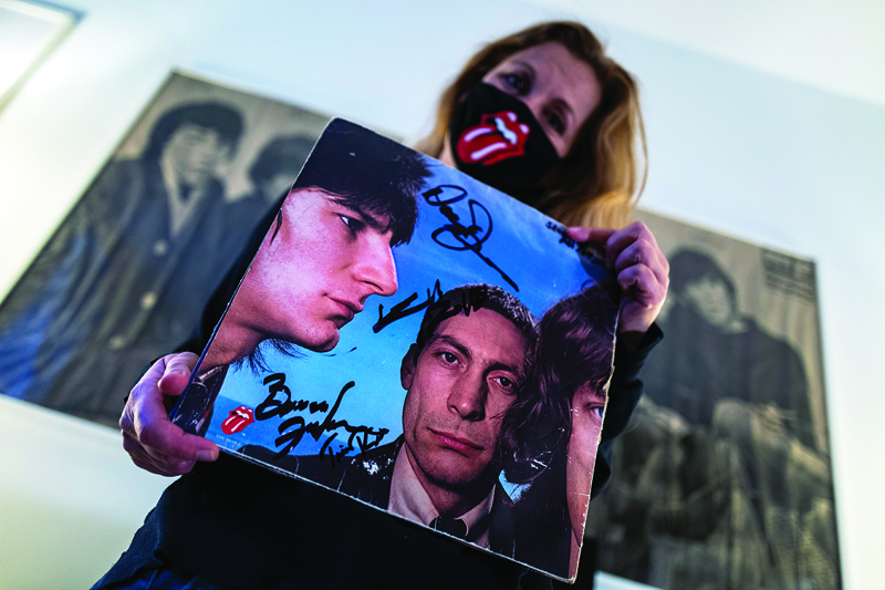 Die-hard Rolling Stones fan Elisabeth Zours poses with an autographed LP album of the legendary British rock band, in Berlin.—AFP n