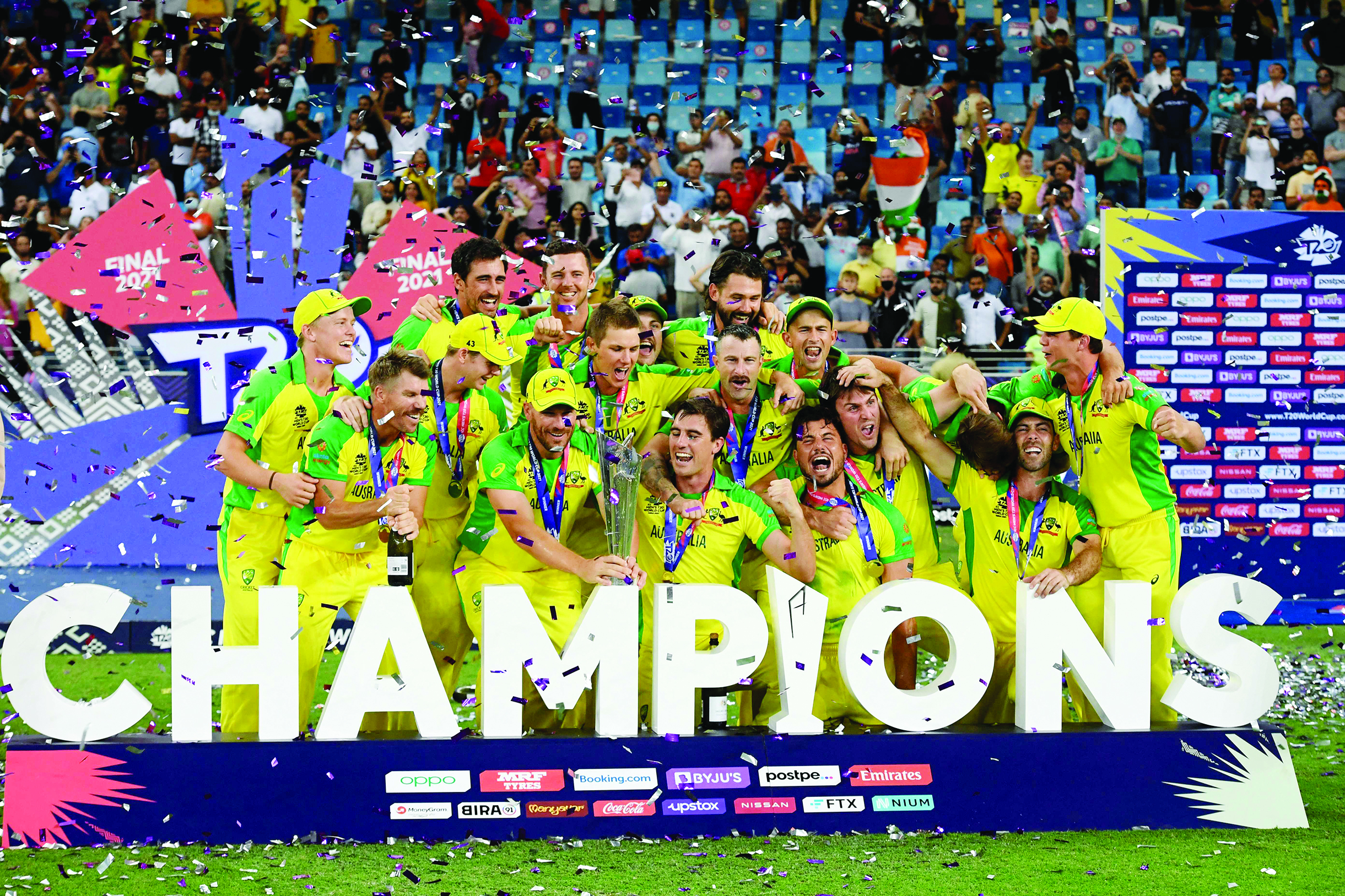 DUBAI: Australia's players pose with the trophy after winning the ICC men's Twenty20 World Cup final match against New Zealand at the Dubai International Cricket Stadium yesterday. - AFP n