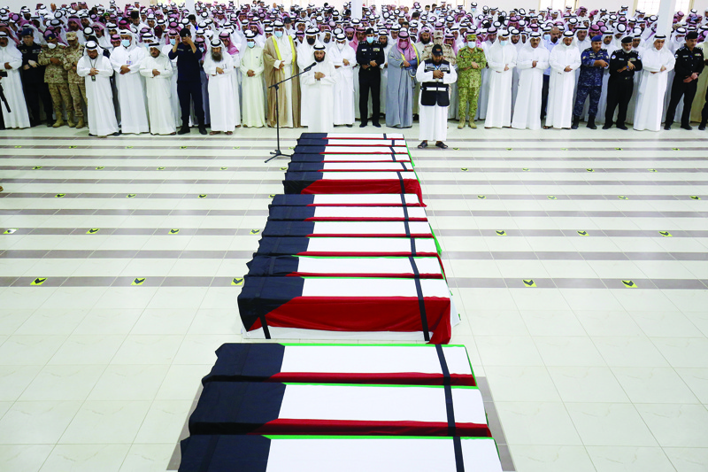 KUWAIT: Mourners and officials pray over the coffins of 19 Kuwaiti prisoners of war (POWs) whose remains were recently found in a mass grave in Iraq and identified following DNA tests, during a funeral before their reburial at a cemetery in Kuwait yesterday. - Photos by Yasser Al-Zayyat n