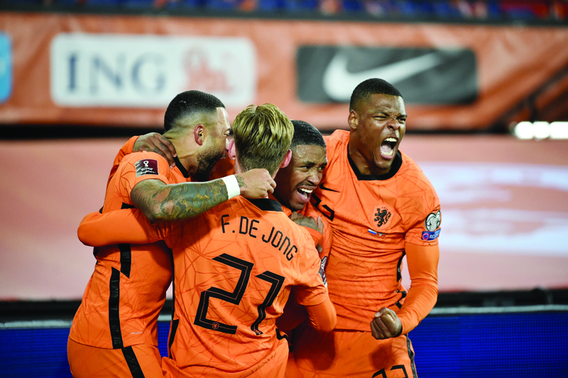 ROTTERDAM: Netherlands' forward Steven Bergwijn (center) celebrates with teammates after scoring his team's first goal during the FIFA World Cup Qatar 2022 qualifying round Group G football against Norway at the Feijenoord stadium in Rotterdam on Tuesday. - AFPn