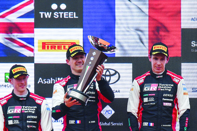 MONZA: France's Sebastien Ogier (center) celebrates his 8th World title with co-driver France's Julien Ingrassia (right) as runner-up Britain's Elfyn Evans (left) looks on, on the podium yesterday after the ACI Rally Monza 2021 of the FIA World Rally Championship at the Monza racetrack, Italy. - AFPn