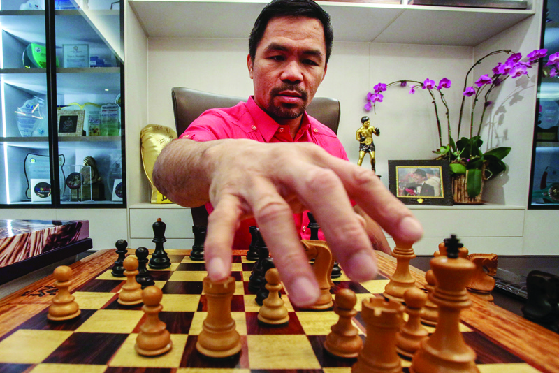 MANILA: In this photo taken on November 11, 2021, Philippine Senator Manny Pacquiao looks at a chessboard after an interview at his residence in Manila. - AFPnn