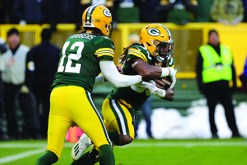 GREEN BAY: Aaron Rodgers #12 of the Green Bay Packers hands the ball off to Aaron Jones #33 during the first quarter at Lambeau Field on Sunday in Green Bay, Wisconsin. - AFPn
