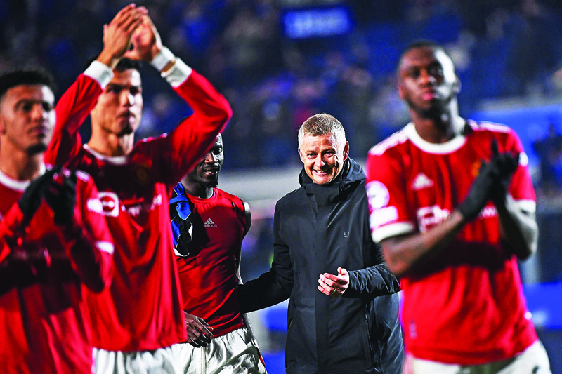 BERGAMO: Manchester United's coach Ole Gunnar Solskjaer smiles next to his players at the end of the UEFA Champions League group F football match against Atalanta at the Azzurri d'Italia stadium, in Bergamo, on Tuesday. – AFPn