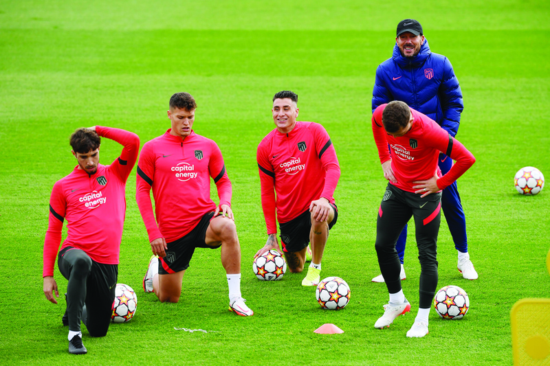 MADRID: Atletico Madrid's Argentinian coach Diego Simeone (right) takes part in training session with Club Atletico de Madrid's players at the Ciudad Deportiva Wanda training ground in Madrid yesterday, on the eve of the UEFA Champions League Group B football match against Liverpool. - AFPnn