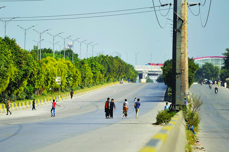 ISLAMABAD: Children play cricket in an empty road blocked by containers (unseen) placed by authorities in Islamabad – and to stop protesters called by the Tehreek-e-Labbaik Pakistan (TLP) demanding the release of their leader Hafiz Saad Hussain Rizvi, son of late Khadim Hussain Rizvi, founder of TLP. – AFP n