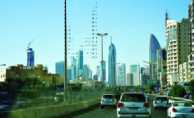 KUWAIT: Vehicles drive on Istiqlal Road yesterday as Kuwait City high rise buildings are seen. —Photo by Fouad Al-Shaikh