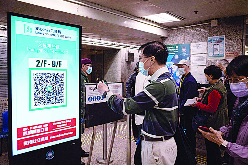 HONG KONG: A man scans a QR code for the government's 'Leave Home Safe' app, used for contact tracing amid the COVID-19 pandemic, to enter Immigration Tower in Hong Kong yesterday. - AFP n